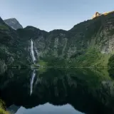 Le lac d'Oo, miroir des montagnes verdoyantes et de sa cascade majestueuse, offre un spectacle paisible.