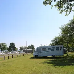 Camping-car stationné près d'un port de plaisance, un endroit idéal pour trouver des spots sur caramaps ou park4night.