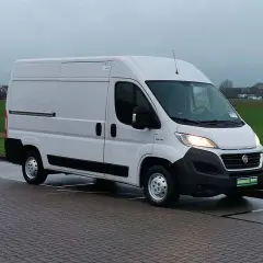 Un fourgon blanc Fiat Ducato 2.3 Multijet 150, symbole de fiabilité, stationné sur un pavé.