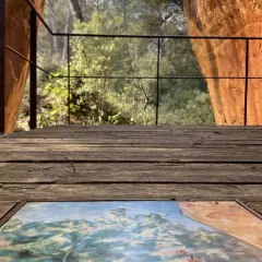 Sur le plateau de Bibemus, un tableau posé sur un pont de bois offre une vue sur la nature environnante, dominée par des falaises ocres.