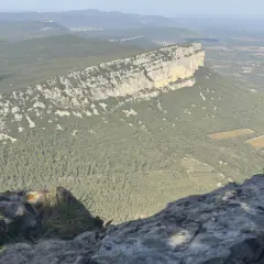 Vue panoramique du pic Saint-Loup, avec sa falaise imposante et la garrigue environnante. Une carte idéale pour les randonneurs.