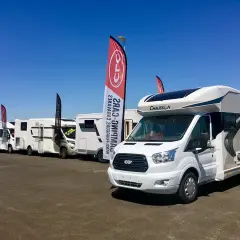 Vente de camping-cars sous un ciel bleu. Découvrez le prix et l'emplacement idéal pour votre futur véhicule de loisirs.