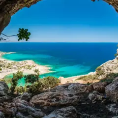 Vue depuis une grotte sur une plage de Crète aux eaux turquoise, idéale pour le snorkeling.