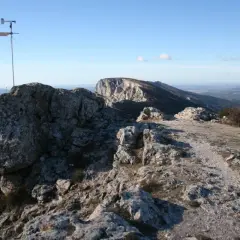 Sommet rocheux avec un anémomètre, offrant une vue panoramique sur la vallée. Le pic des mouches altitude est un lieu idéal pour observer le vent.