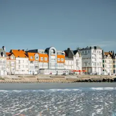 Bâtiments colorés bordant la plage sur la Côte d'Opale, avec des toits orange vif et des façades blanches et grises.