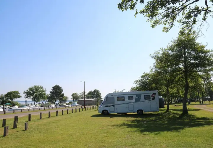 Camping-car stationné près d'un port de plaisance, un endroit idéal pour trouver des spots sur caramaps ou park4night.