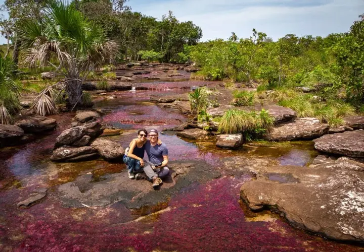 Un couple profite du Caño Cristales, la rivière aux cinq couleurs, une merveille à voir quand on se demande que faire en Colombie.