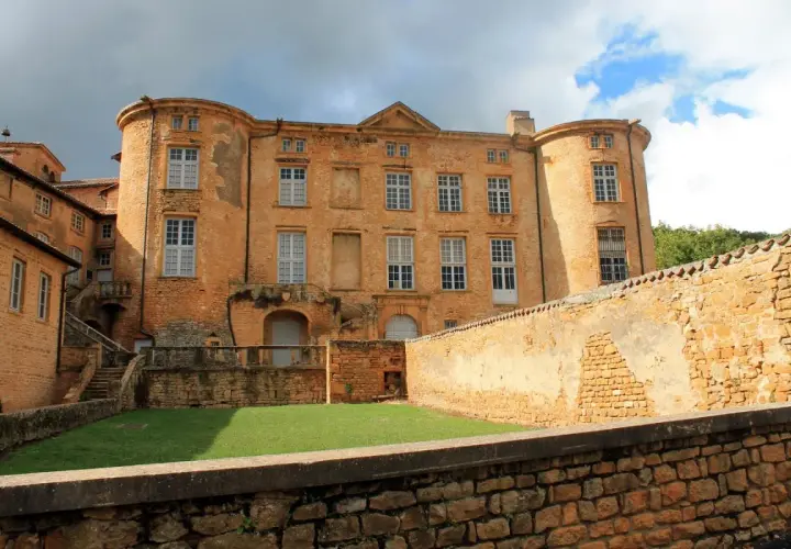 Château de Oingt, joyau du circuit des pierres dorées, se dresse fièrement sous un ciel orageux.