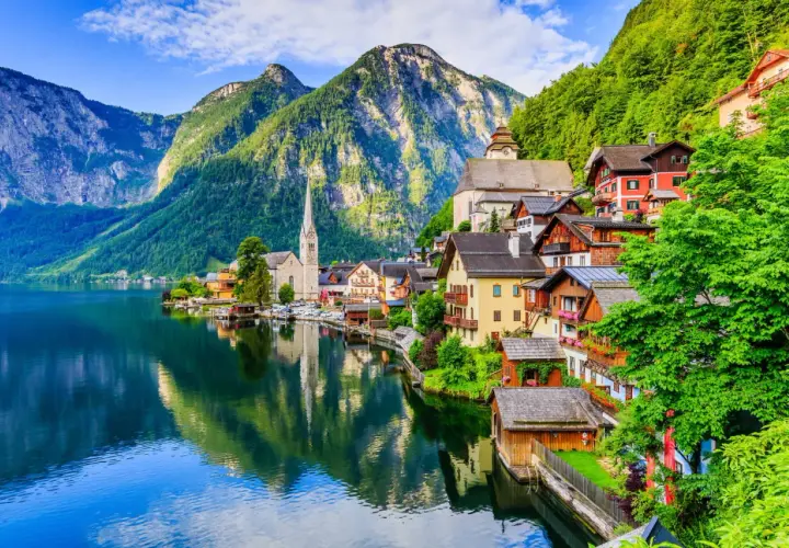 Village pittoresque au bord d'un lac, montagnes verdoyantes en arrière-plan. Idéal pour savoir que faire en Autriche.