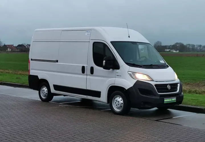 Un fourgon blanc Fiat Ducato 2.3 Multijet 150, symbole de fiabilité, stationné sur un pavé.