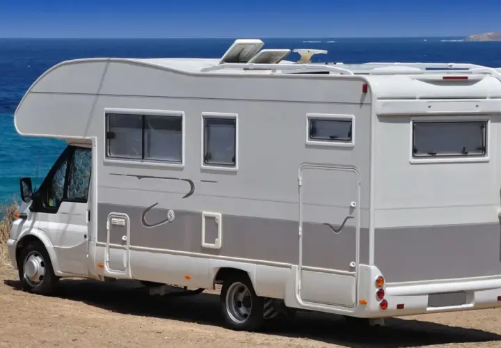 Camping-car blanc stationné sur une aire de camping-car à Bormes-les-Mimosas, face à la mer Méditerranée.