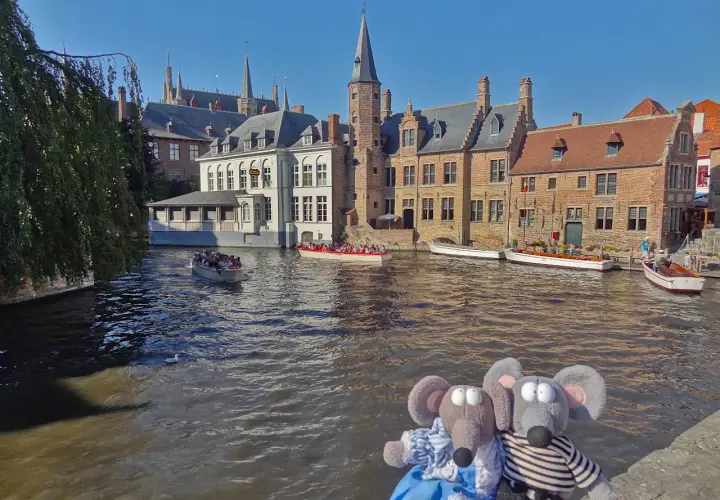 Deux peluches souris profitent d'une balade en bateau sur les canaux de Bruges, une excellente idée pour savoir que faire à Bruges.