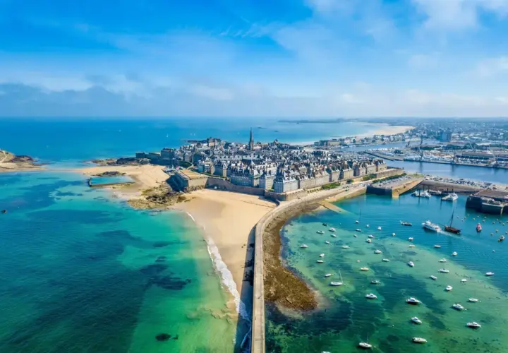 Vue aérienne de Saint-Malo, ville fortifiée sur la côte bretonne. La mer d'un bleu turquoise baigne ce magnifique pays malouin, parsemé de bateaux.