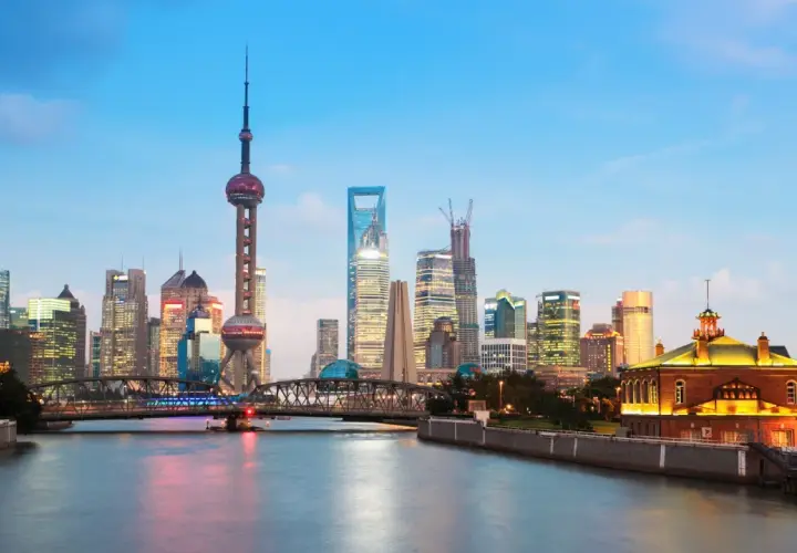 Vue de la skyline de Shanghai au crépuscule, avec la tour de la Perle de l'Orient et des gratte-ciel illuminés. Idéal pour savoir que faire à Shanghai.