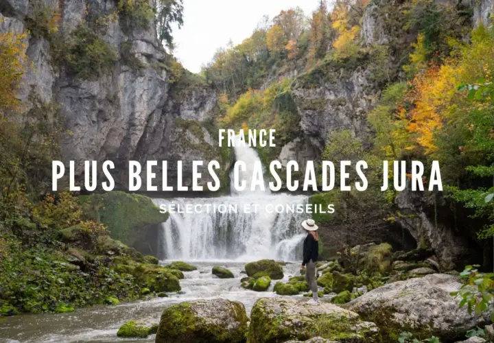 Une femme admire une magnifique cascade dans le Jura, entourée de rochers moussus et d'arbres aux couleurs d'automne.
