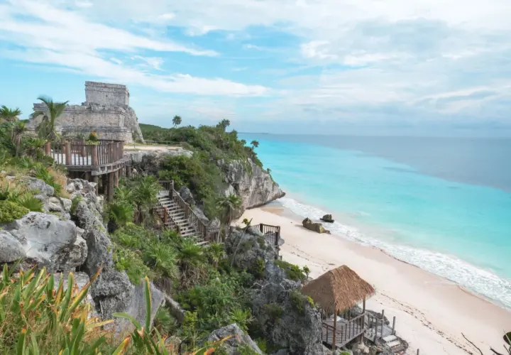 Ruines mayas sur une falaise surplombant une plage de sable blanc et une mer turquoise. Idéal pour savoir que faire au Mexique.