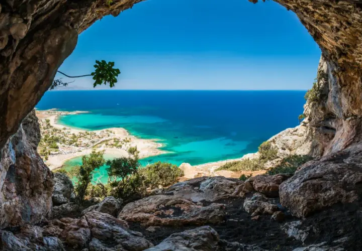 Vue depuis une grotte sur une plage de Crète aux eaux turquoise, idéale pour le snorkeling.