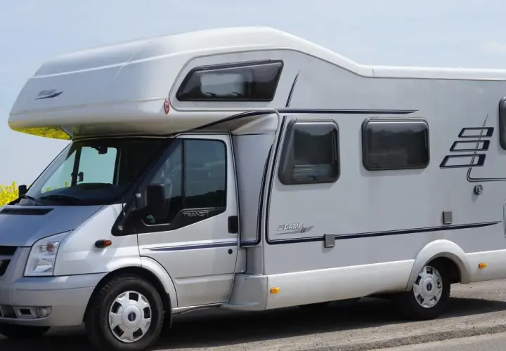 Camping car Hymer sur le bord du canal de Nantes à Brest, au milieu d'un champ de colza en fleurs.