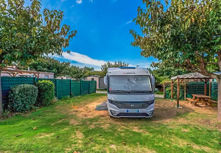 Un camping-car Adria prêt pour l'aventure sur l'Île d'Oléron. Un coin paisible avec pelouse et abri pique-nique.
