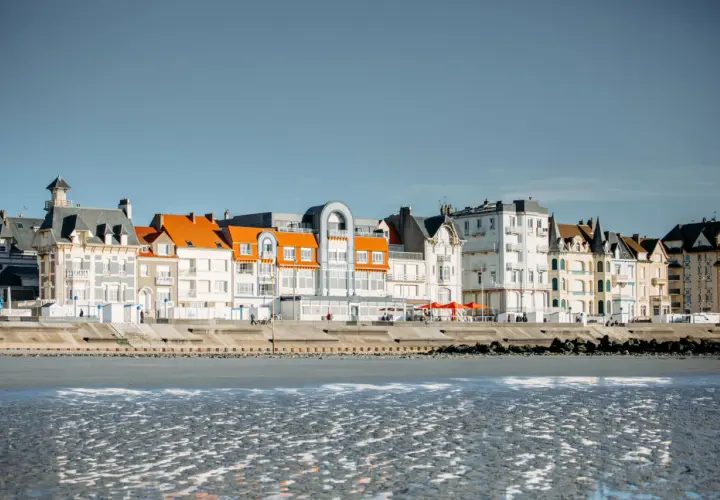 Bâtiments colorés bordant la plage sur la Côte d'Opale, avec des toits orange vif et des façades blanches et grises.