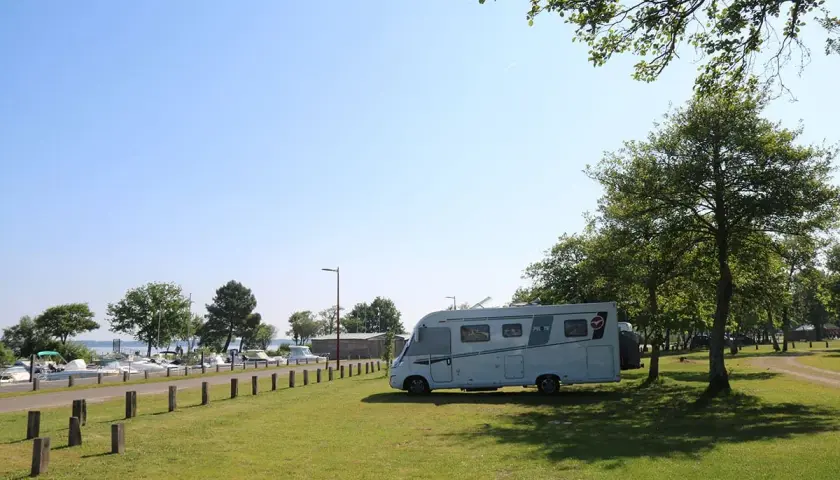 Camping-car stationné près d'un port de plaisance, un endroit idéal pour trouver des spots sur caramaps ou park4night.