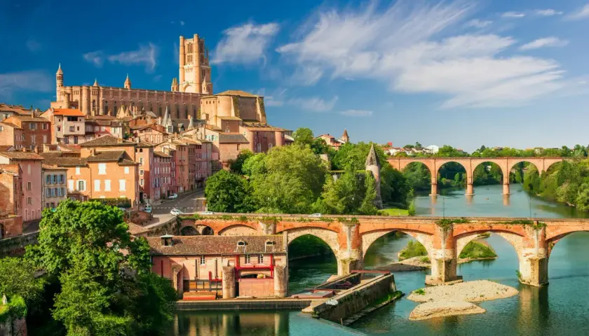 Vue d'Albi, une ville d'Occitanie, avec sa cathédrale imposante et ses ponts en briques sur le Tarn. Idéal pour savoir que faire en Occitanie.