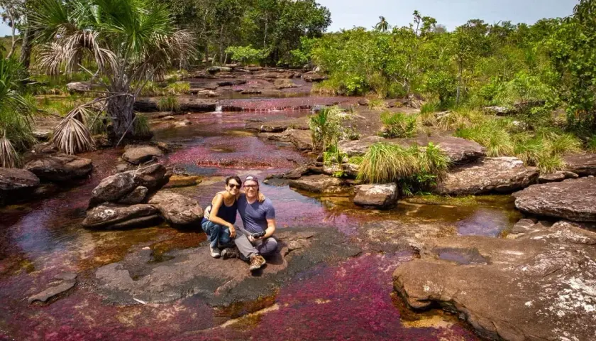 Un couple profite du Caño Cristales, la rivière aux cinq couleurs, une merveille à voir quand on se demande que faire en Colombie.