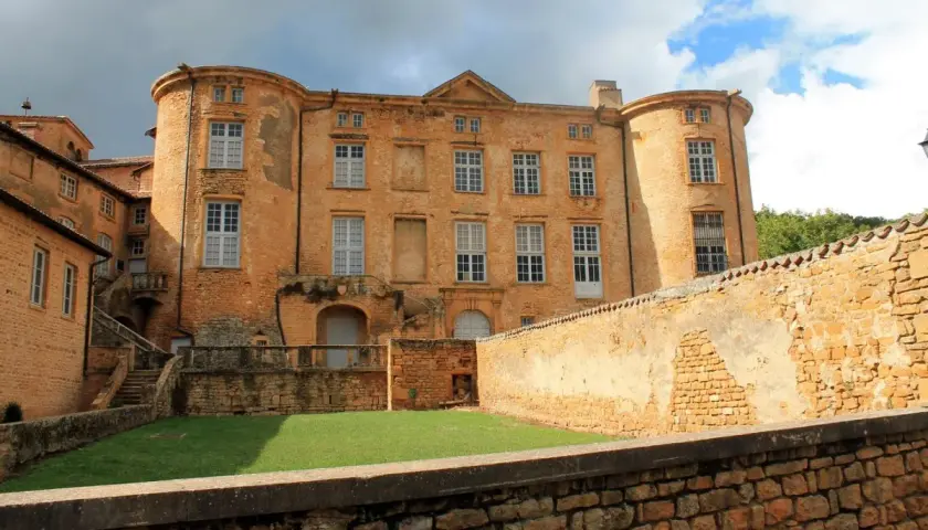 Château de Oingt, joyau du circuit des pierres dorées, se dresse fièrement sous un ciel orageux.