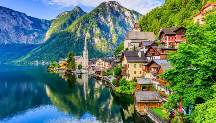 Village pittoresque au bord d'un lac, montagnes verdoyantes en arrière-plan. Idéal pour savoir que faire en Autriche.