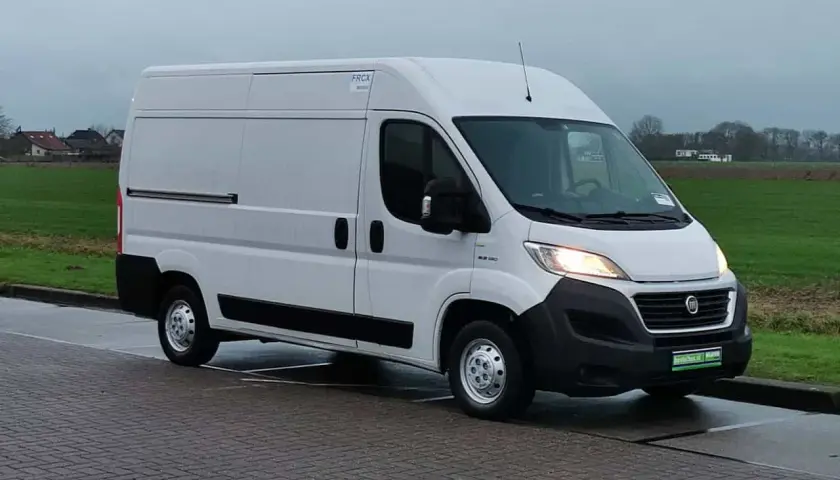 Un fourgon blanc Fiat Ducato 2.3 Multijet 150, symbole de fiabilité, stationné sur un pavé.