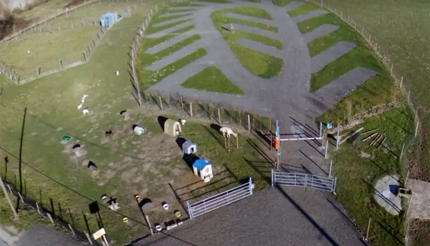 Vue aérienne de la ferme de Bihen avec des animaux, des abris et des emplacements de camping aménagés.