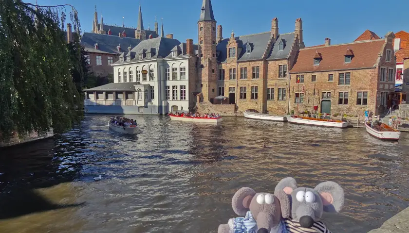 Deux peluches souris profitent d'une balade en bateau sur les canaux de Bruges, une excellente idée pour savoir que faire à Bruges.