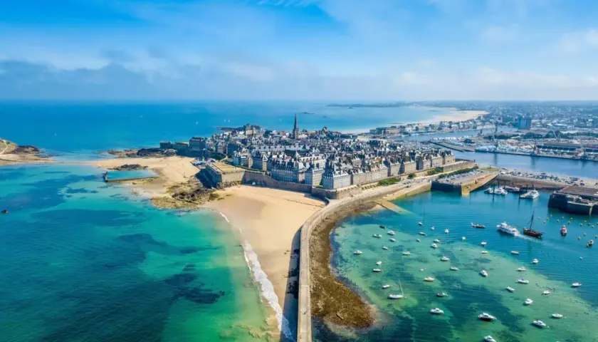 Vue aérienne de Saint-Malo, ville fortifiée sur la côte bretonne. La mer d'un bleu turquoise baigne ce magnifique pays malouin, parsemé de bateaux.