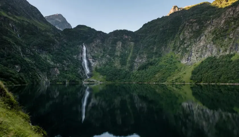 Le lac d'Oo, miroir des montagnes verdoyantes et de sa cascade majestueuse, offre un spectacle paisible.