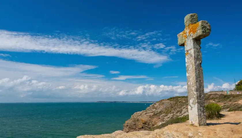 Croix de pierre patinée par le temps, dominant la mer d'un bleu profond. Une belle balade sur la presqu'île de Rhuys.