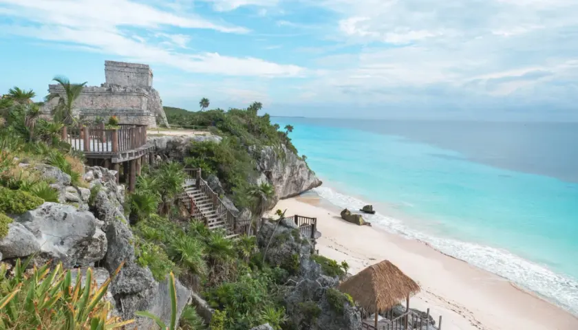 Ruines mayas sur une falaise surplombant une plage de sable blanc et une mer turquoise. Idéal pour savoir que faire au Mexique.