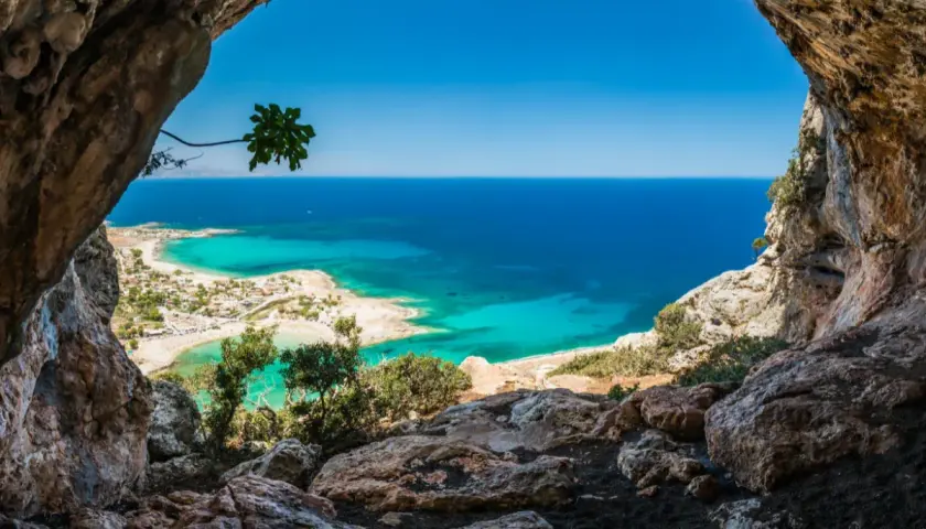 Vue depuis une grotte sur une plage de Crète aux eaux turquoise, idéale pour le snorkeling.
