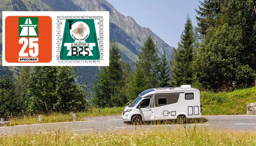 Un camping-car blanc roule sur une route de montagne en Suisse, avec une vignette autoroutière visible.