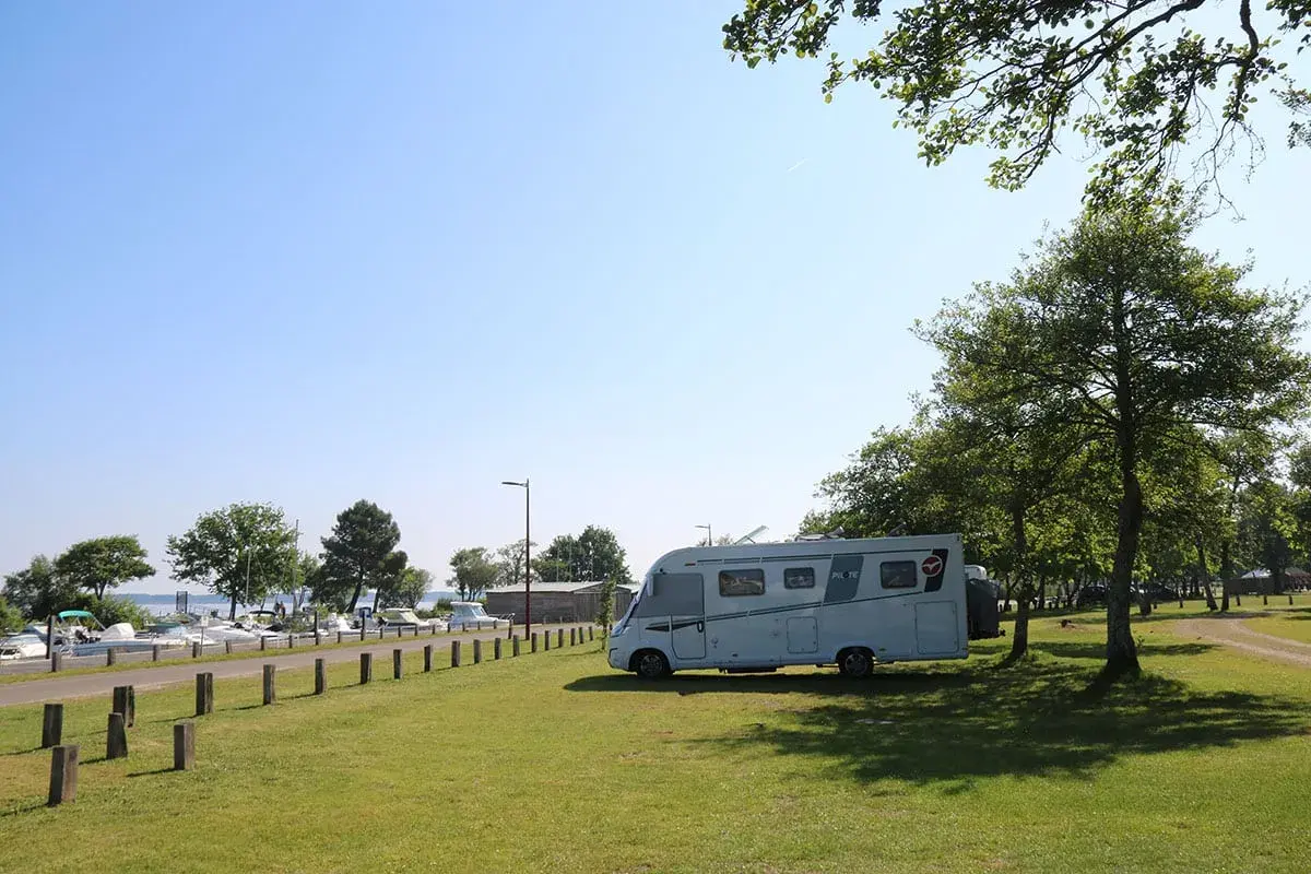 Camping-car stationné près d'un port de plaisance, un endroit idéal pour trouver des spots sur caramaps ou park4night.