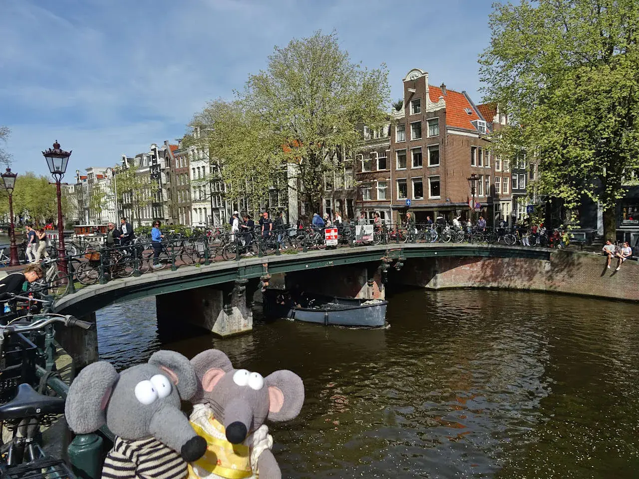 Deux peluches éléphants profitent des activités à découvrir à Amsterdam : un pont animé, des canaux et des maisons typiques.