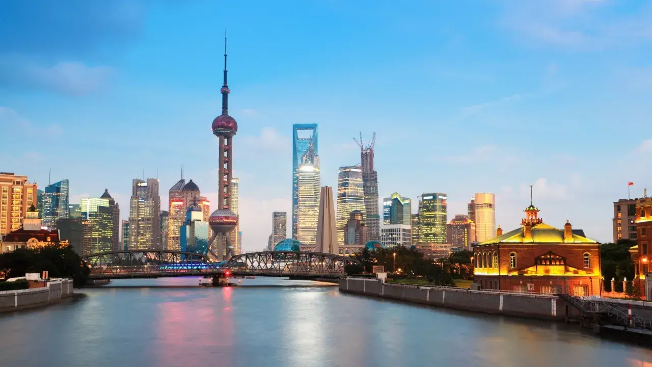 Vue de la skyline de Shanghai au crépuscule, avec la tour de la Perle de l'Orient et des gratte-ciel illuminés. Idéal pour savoir que faire à Shanghai.