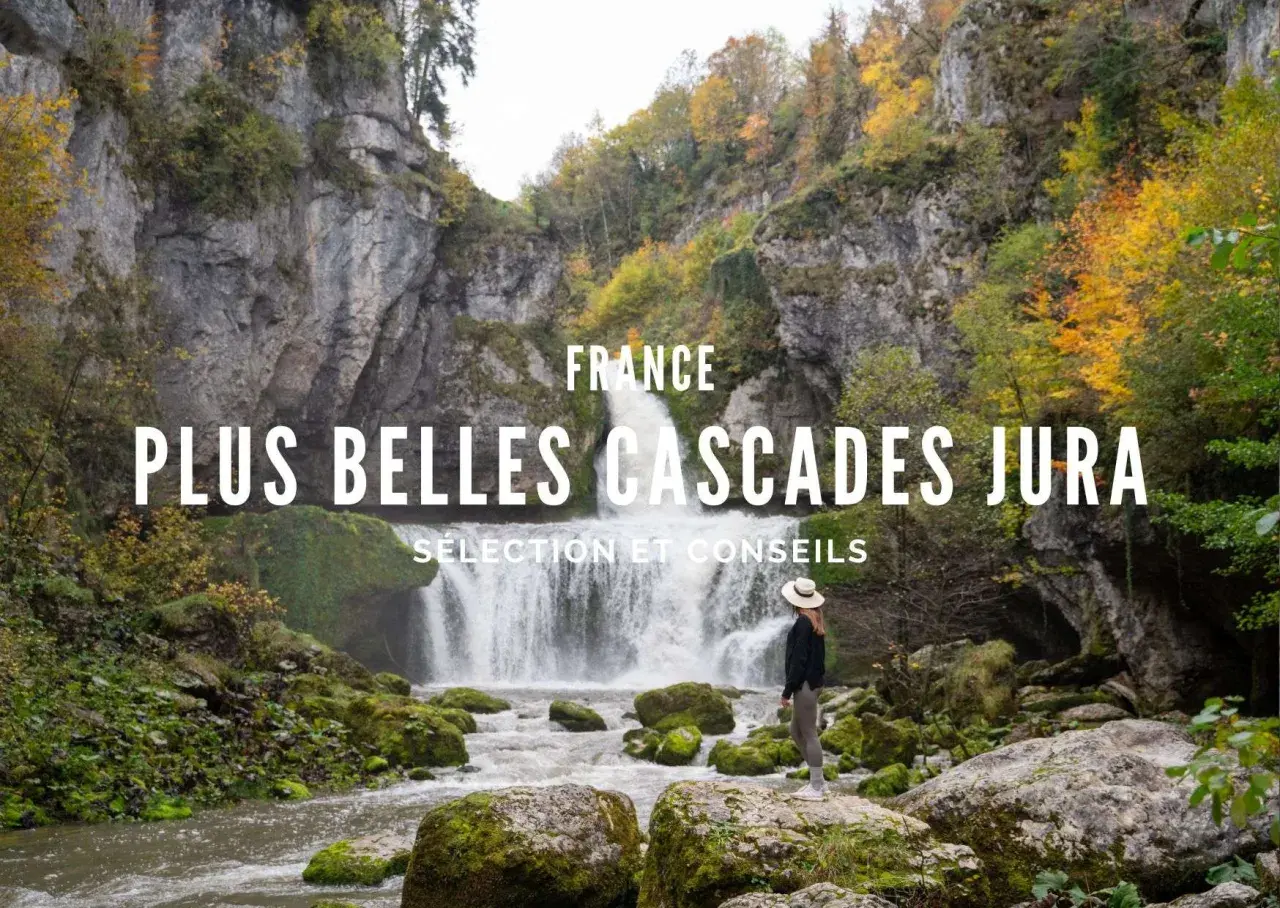 Une femme admire une magnifique cascade dans le Jura, entourée de rochers moussus et d'arbres aux couleurs d'automne.