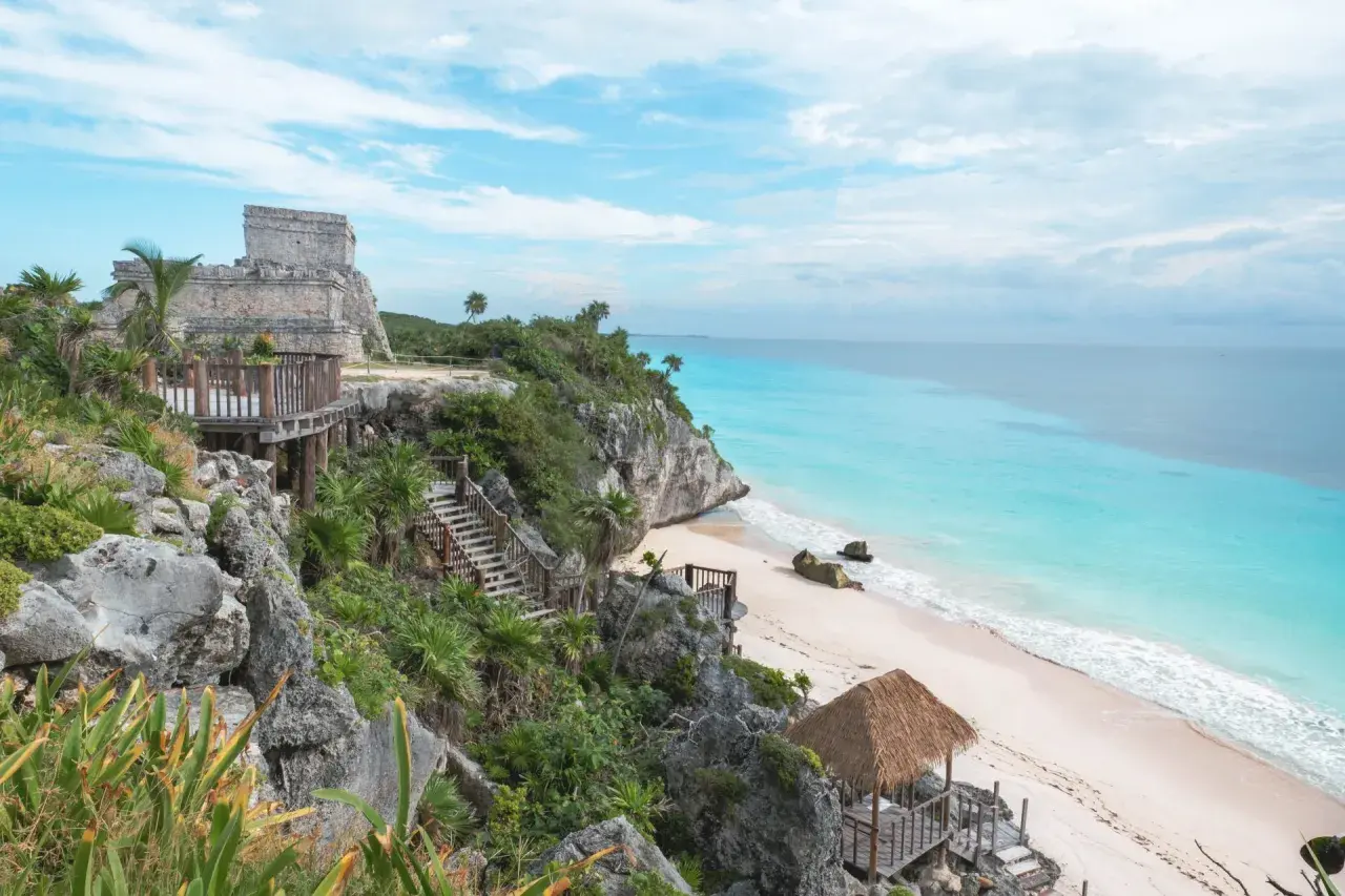 Ruines mayas sur une falaise surplombant une plage de sable blanc et une mer turquoise. Idéal pour savoir que faire au Mexique.