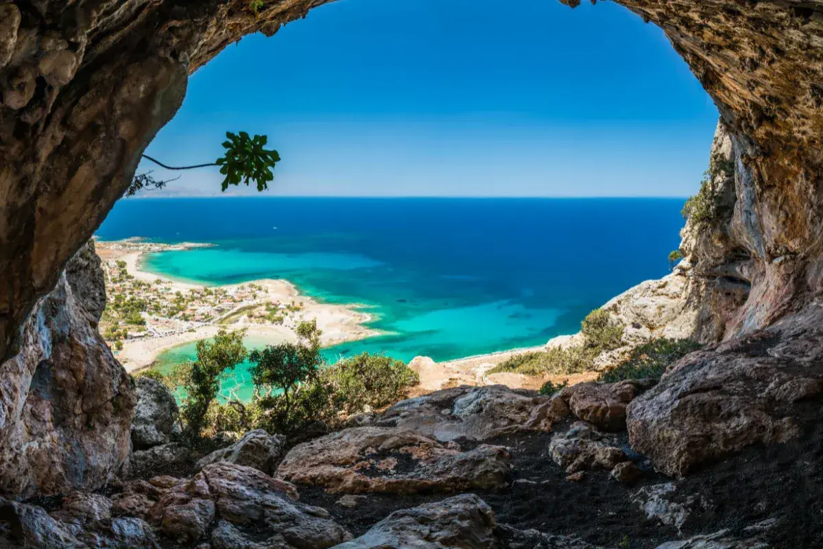 Vue depuis une grotte sur une plage de Crète aux eaux turquoise, idéale pour le snorkeling.