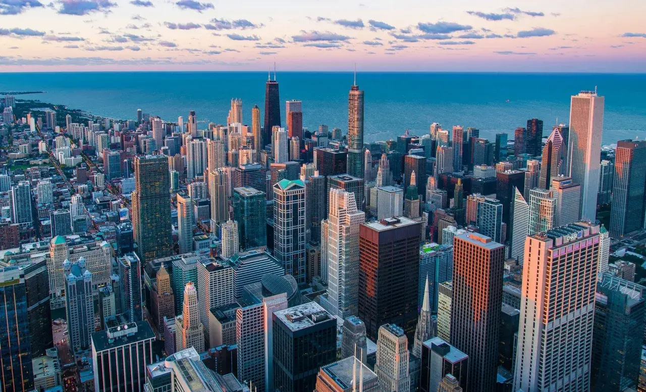 Vue aérienne de la skyline de Chicago au coucher du soleil, avec le lac Michigan en arrière-plan. Idéal pour savoir que faire à Chicago.