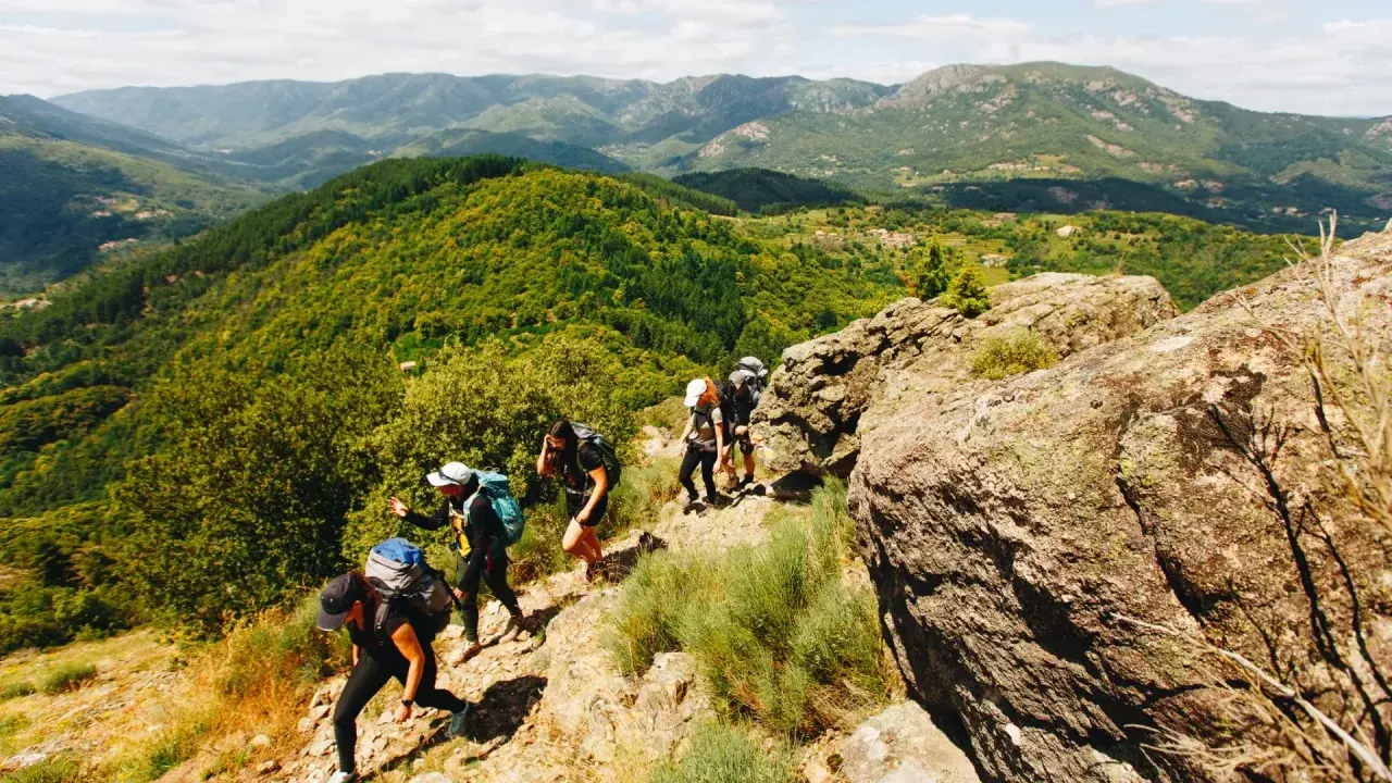 Groupe de randonneurs en Ardèche, profitant d'une randonnée de 5 jours à travers des paysages montagneux verdoyants.