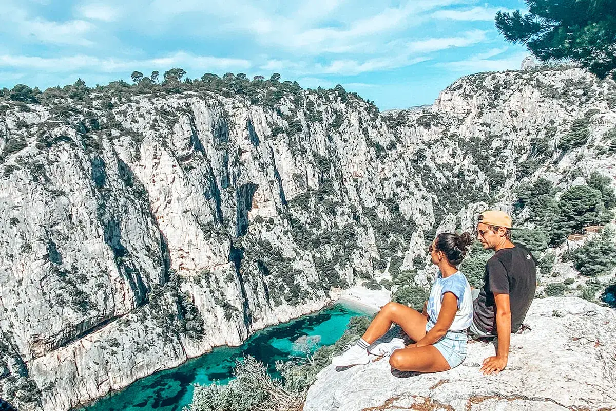 Couple admirant une calanque aux eaux turquoise, un aperçu de ce que faire autour de Marseille.