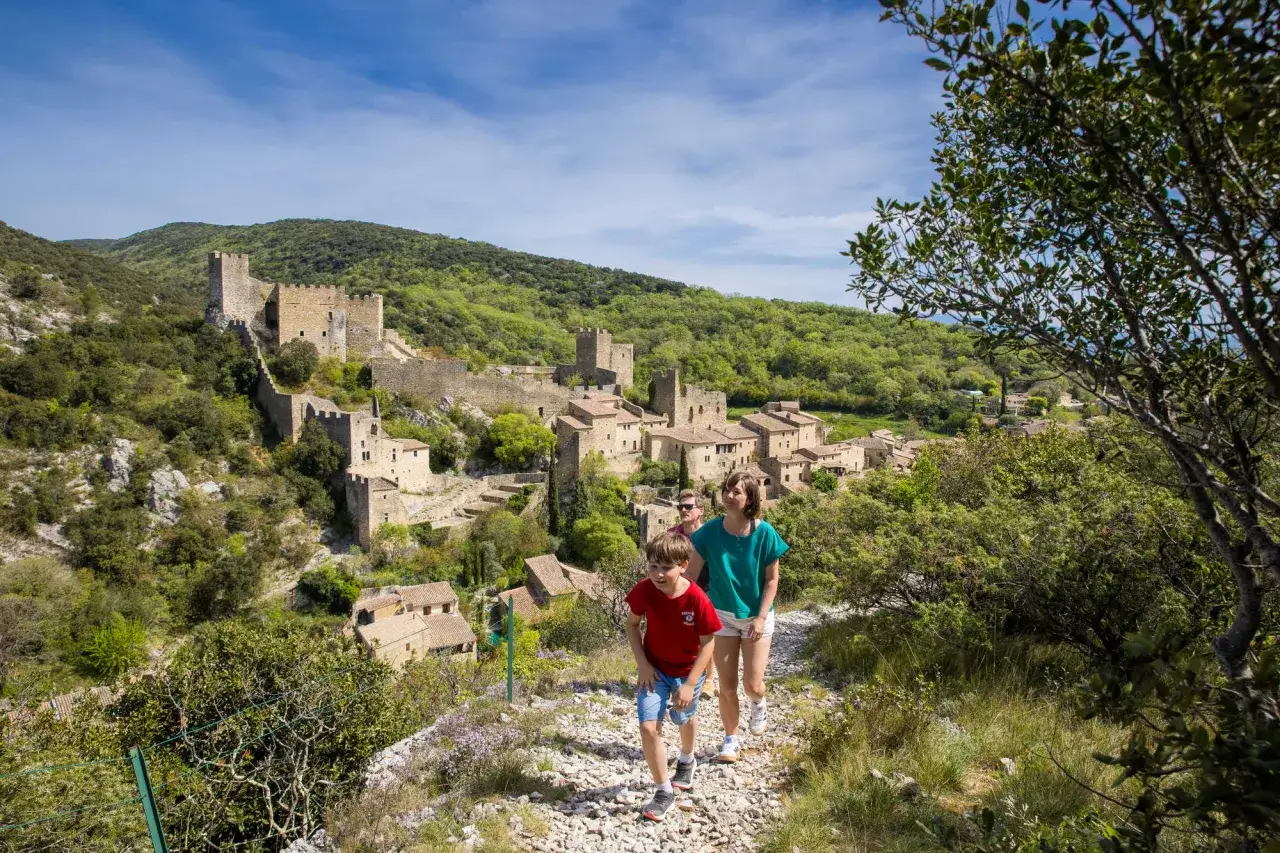 Famille en randonnée Ardèche 5 jours, découvrant un village médiéval perché et son château.