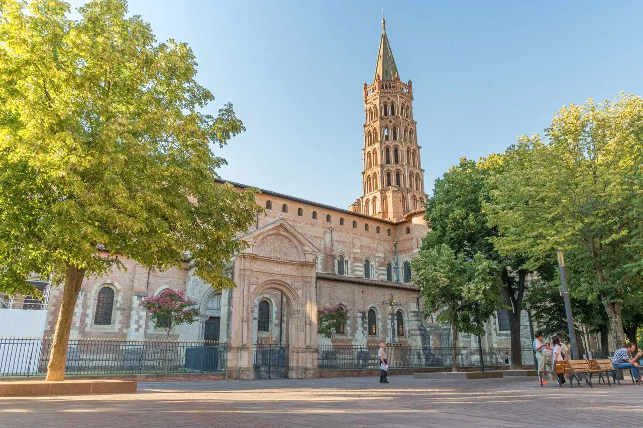 La basilique Saint-Sernin, un incontournable pour savoir que faire à Toulouse. L'architecture romane et son clocher octogonal dominent la place.
