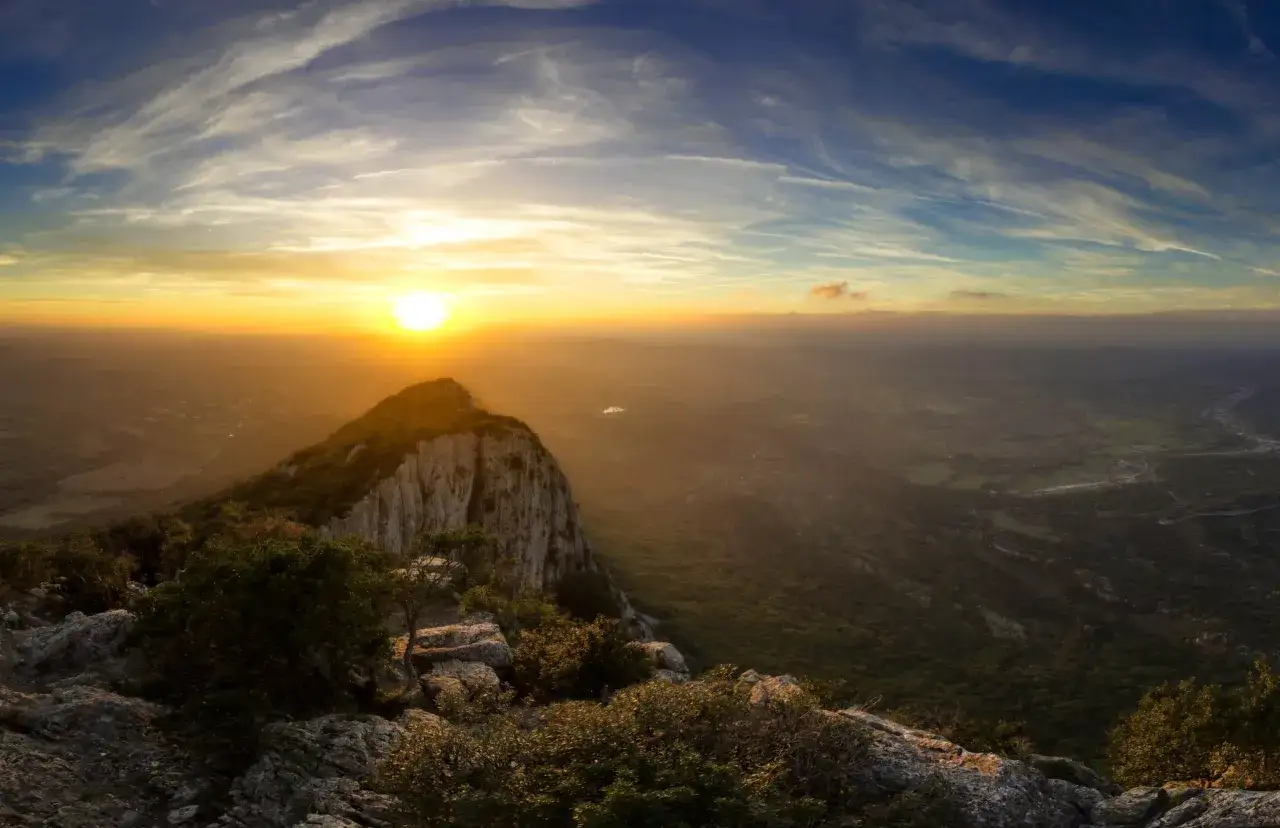 Coucher de soleil spectaculaire sur le pic Saint-Loup, baignant le paysage de ses rayons dorés.
